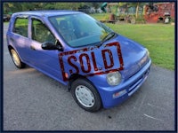 a blue car with a sold sign on it