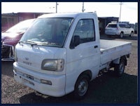 a small white truck is parked in a parking lot