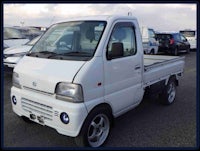 a small white truck parked in a parking lot