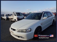 a white honda accord is parked in a parking lot