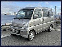 a small silver van parked on the side of the road