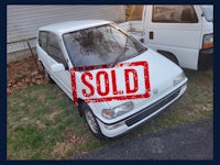 a white car with a sold sign on it